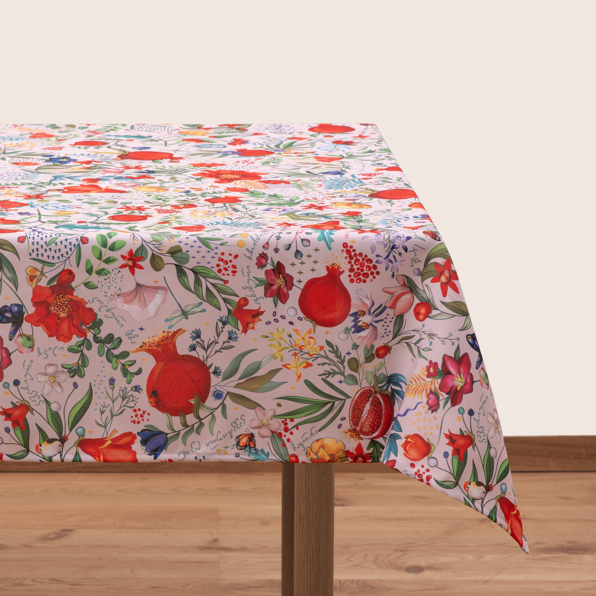Light cream tablecloth with pomegranate and floral pattern laid flat
