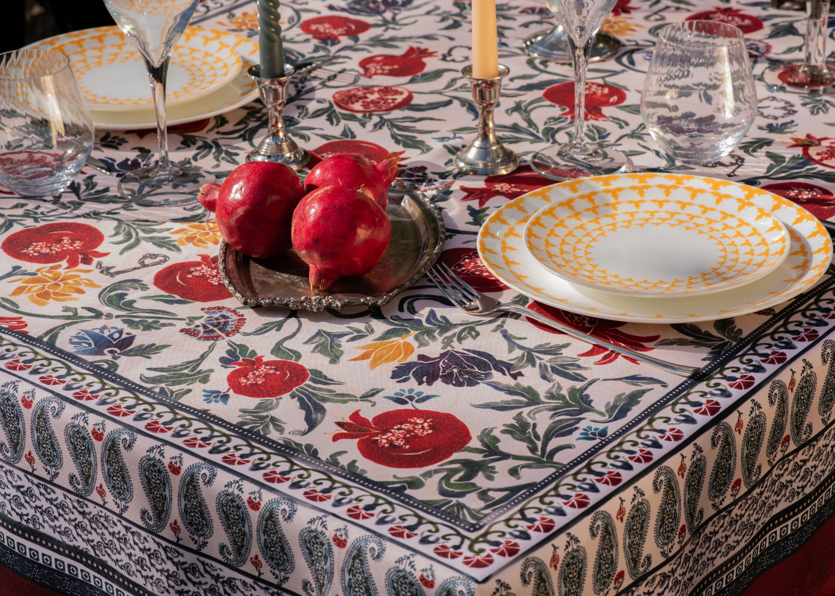 Red tablecloth with alphabet script and pomegranate motifs on white background