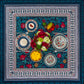 Flat lay of the BlueTabla blue pomegranate tablecloth, set with four patterned plates, a floral centrepiece, fruit and desserts.