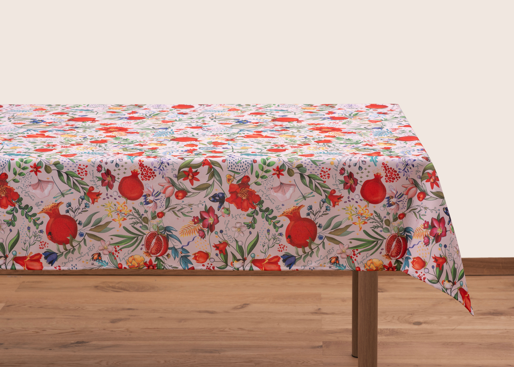 Light cream tablecloth with pomegranate and floral pattern laid flat