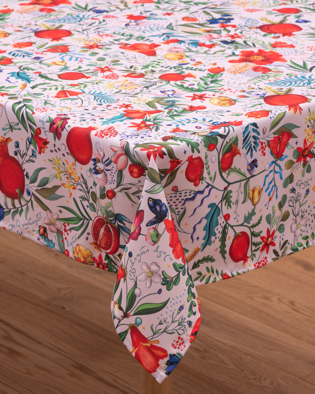 Light cream tablecloth with pomegranate and floral pattern laid flat